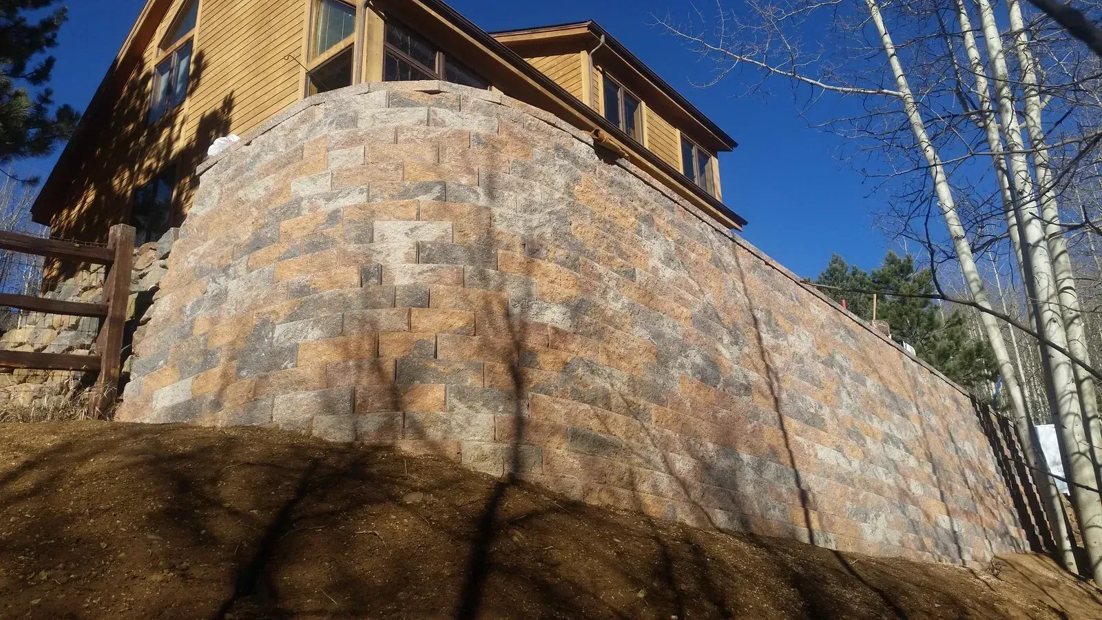 Custom stone retaining wall and deck structure on a Colorado mountain home